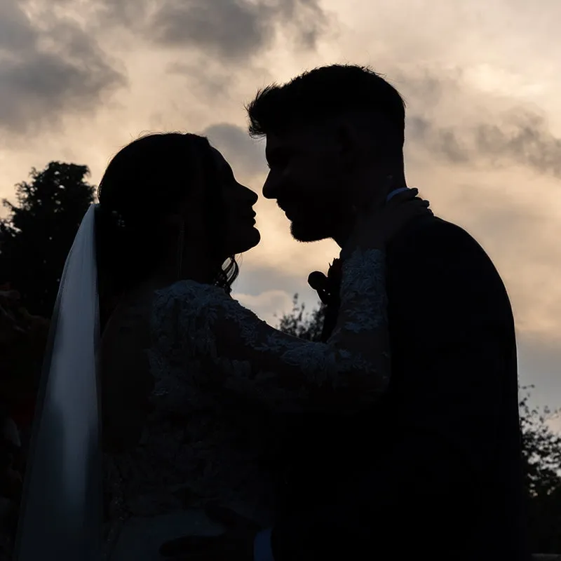 Silhouette of the couple sharing a kiss at sunset