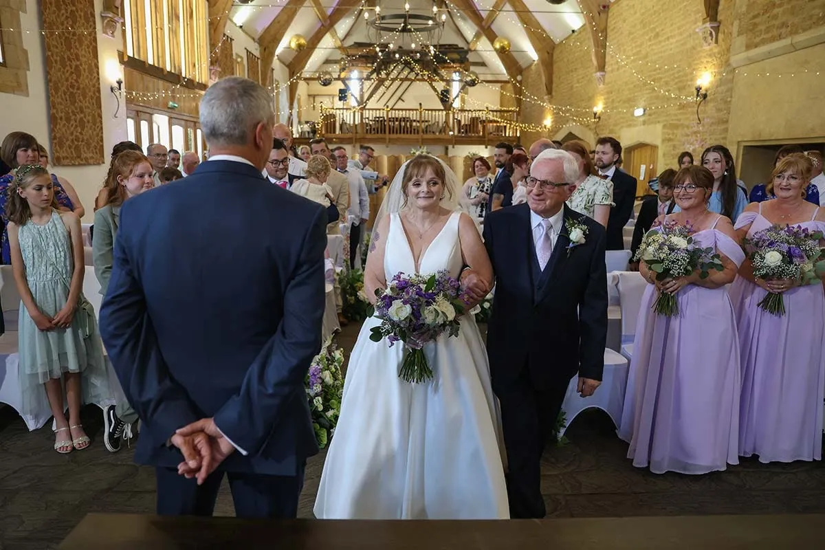 Bride and groom leaving the ceremony through their guests