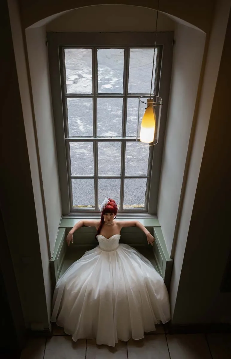 Bride photographed in the window of the manor house