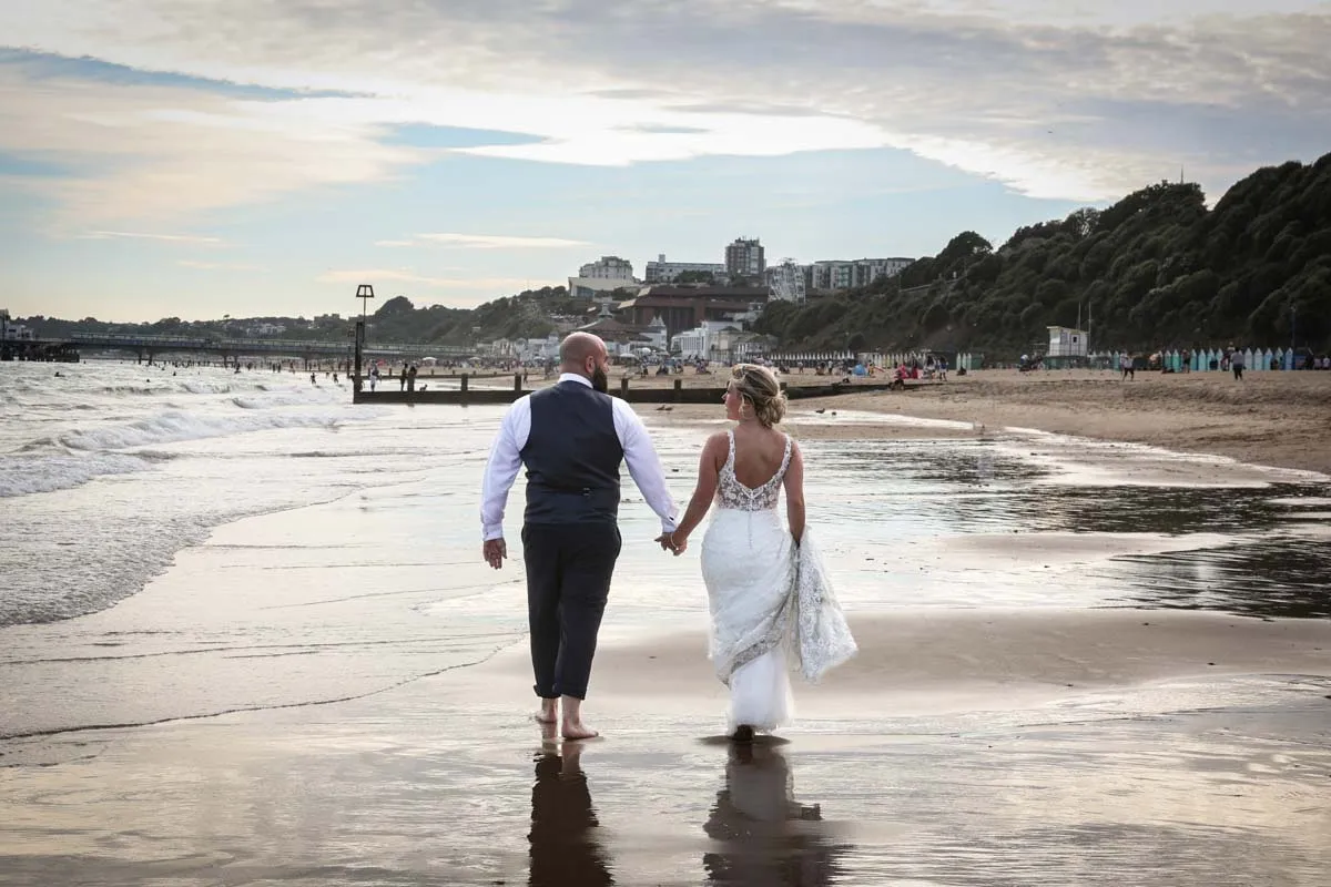 Bride and groom walking on the beach